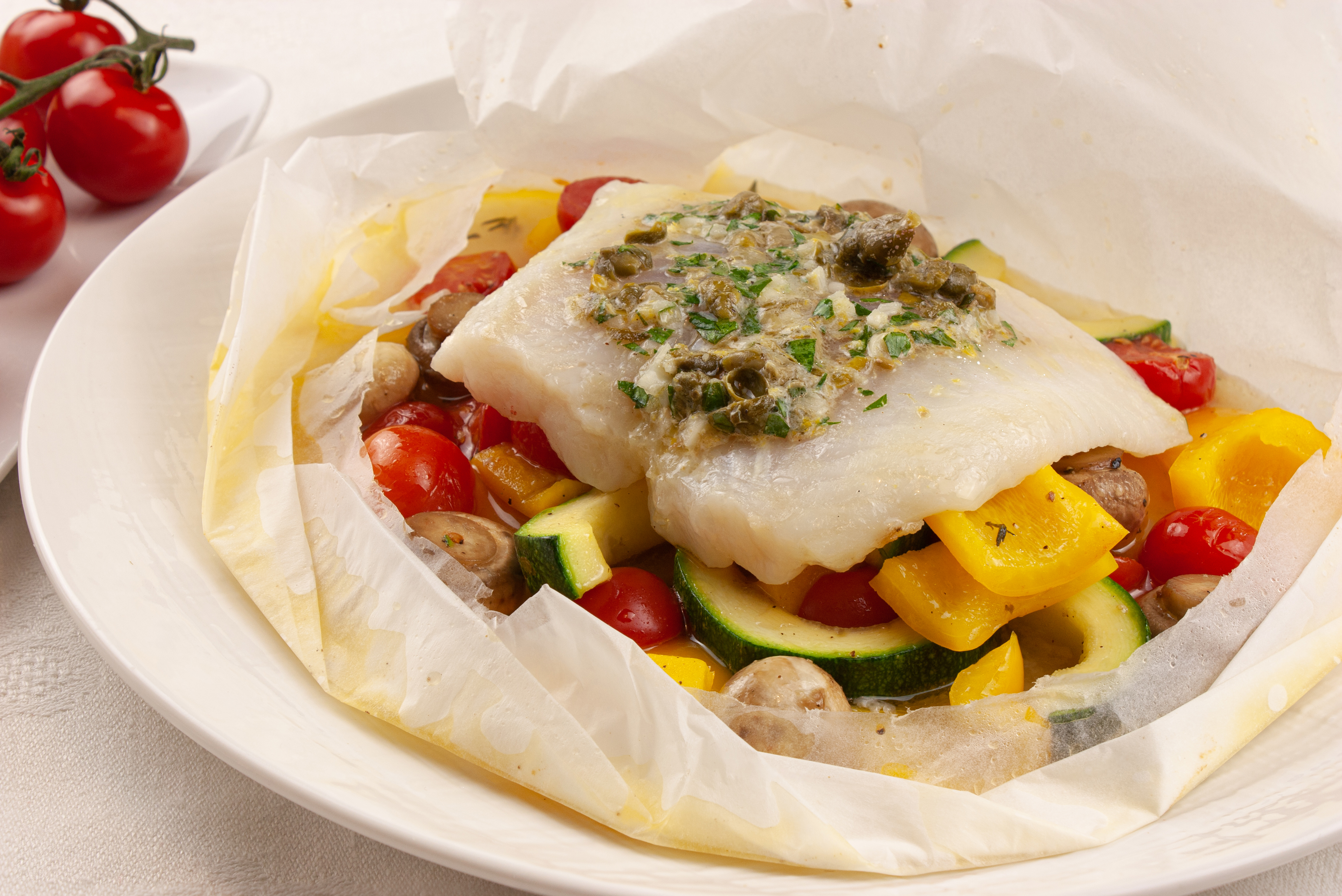 Готовая папильотка с рыбой, овощами и каперсовым маслом.