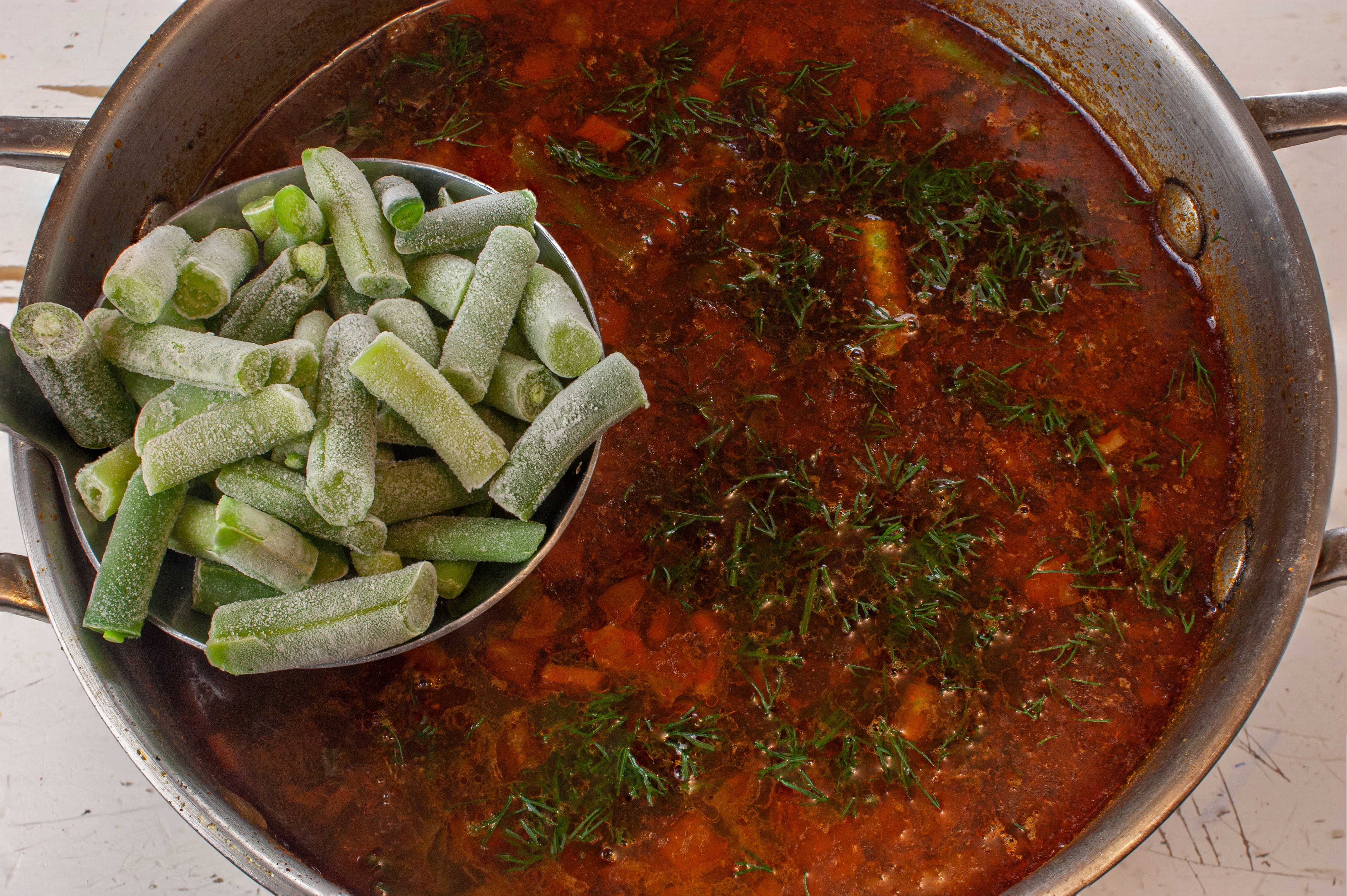 Закладываем укроп и мороженую фасоль.